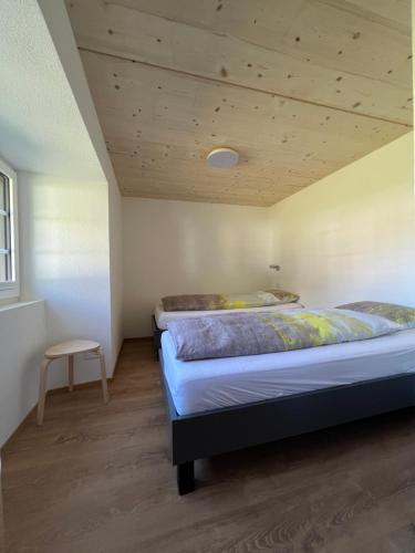 two beds in a bedroom with a wooden ceiling at Ferienhaus Capricorn **** in Saas-Grund