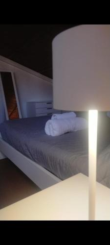 a bedroom with a bed with a white pillow and a lamp at Loft Belvedere in Sulmona