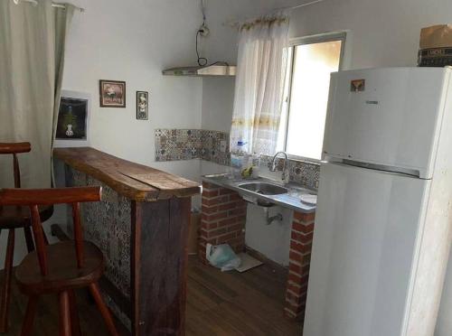 a kitchen with a white refrigerator and a sink at Chalé da Ju in Sao Jorge