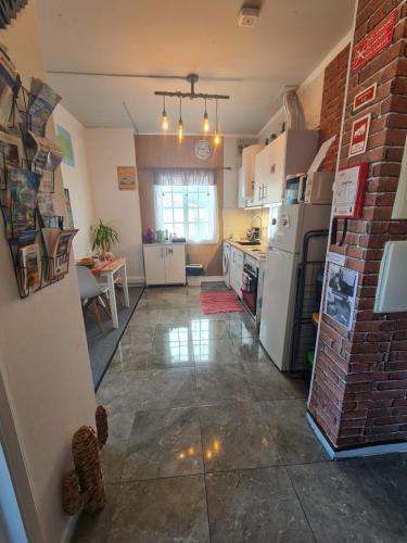 uma cozinha com electrodomésticos brancos e uma parede de tijolos em Cozy apartment close to airport em Ponta Delgada