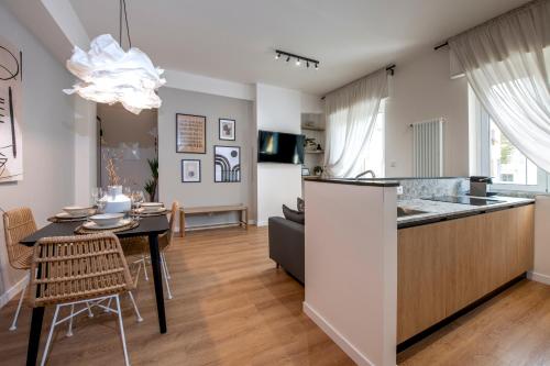 a kitchen and living room with a table and a dining room at 224 - Ma & Ma Luxury Apartment, 500metri da mare e spiaggia, vicino alla Baia del Silenzio - PARCHEGGIO GRATIS PRIVATO INCLUSO in Sestri Levante