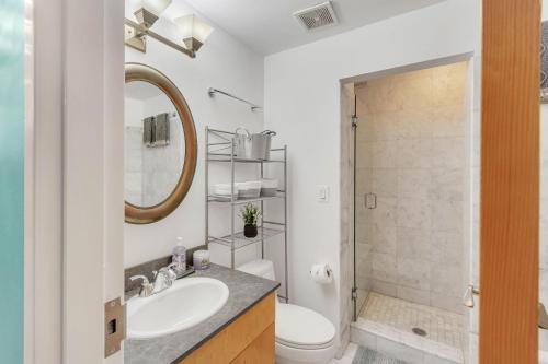 a bathroom with a sink and a toilet and a mirror at Broad Street Apartment in Philadelphia