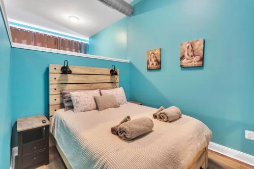 Broad Street Apartment في فيلادلفيا: غرفة نوم بجدران زرقاء وسرير مع وسادتين