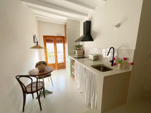 a kitchen with a counter and a table and a sink at Casa Petita, Villajoyosa in Villajoyosa
