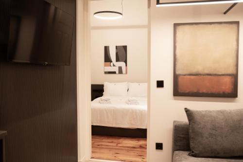 a room with a bed and a couch and a television at Taskou Luxury Suites in Thessaloniki