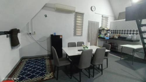 a dining room with a table and chairs at Nour Homestay in Kaki Bukit