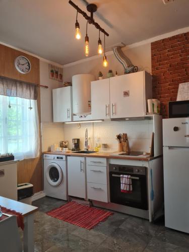 Cozy apartment close to airport في بونتا ديلغادا: مطبخ بدولاب بيضاء وغسالة ملابس