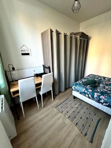 - une chambre avec un bureau, un lit, une table et des chaises dans l'établissement Le Green Twin, au Havre