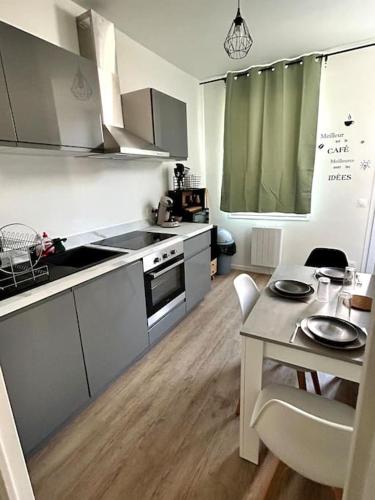 une cuisine avec une table et une cuisine avec une salle à manger dans l'établissement Le Green Twin, au Havre
