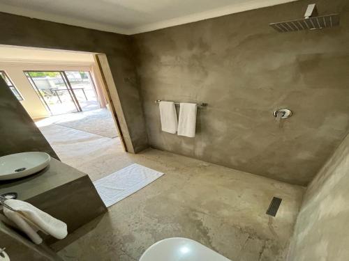 a bathroom with a sink and a toilet and a shower at The Guesthouse Kokstad in Kokstad