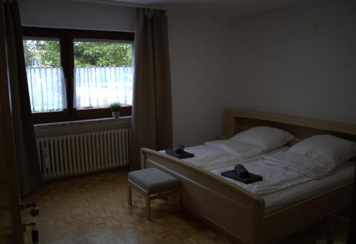 a bedroom with a bed with a window and a chair at Fremdenzimmer Klinge in Haina