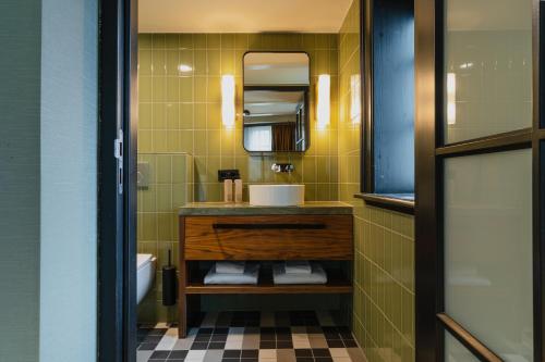 La salle de bains est pourvue d'un lavabo et d'un miroir. dans l'établissement Hotel Mai Amsterdam, à Amsterdam