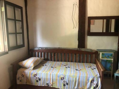 ein Schlafzimmer mit einem Bett mit einer Decke darauf in der Unterkunft CASA DE PRAIA BOIÇUCANGA 5 Quartos PISCINA, SAUNA, CHURRASQUEIRA in São Sebastião
