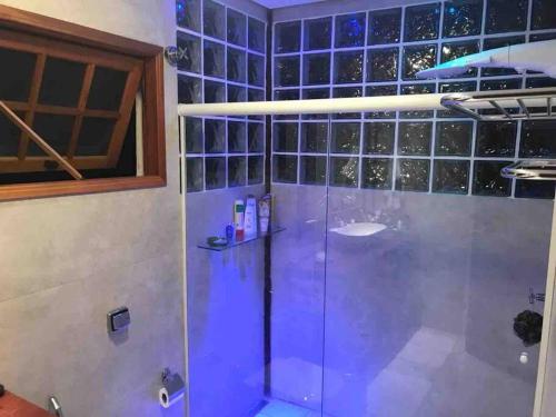 eine Dusche im Bad mit blauen Fliesen in der Unterkunft CASA DE PRAIA BOIÇUCANGA 5 Quartos PISCINA, SAUNA, CHURRASQUEIRA in São Sebastião