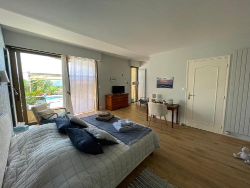 a bedroom with a large bed with blue pillows at Jardin des Chats in Sévignacq-Meyracq