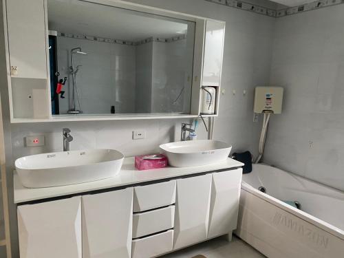 a bathroom with two sinks and a mirror and a tub at Kim Villa Swan Bay - Zone 8 in Phước Lý