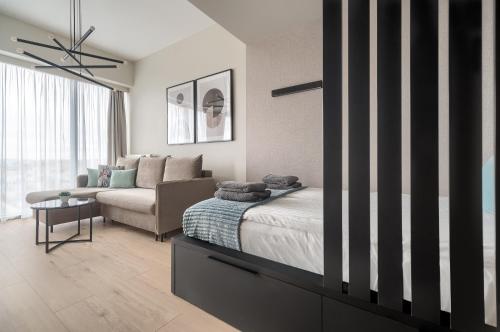 a bedroom with a bed and a couch at Margi Smart Apartament HANZA POOL SAUNA in Szczecin