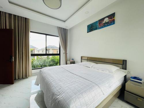 a bedroom with a large bed and a large window at Kim Villa Swan Bay - Zone 8 in Phước Lý