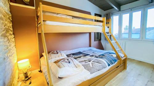 ein Etagenbett mit einer Leiter in einem Zimmer in der Unterkunft Jolie maison avec cour dans le centre du village in La Couarde-sur-Mer