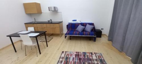 a living room with a table and a couch and a kitchen at Moon in Pignataro Maggiore