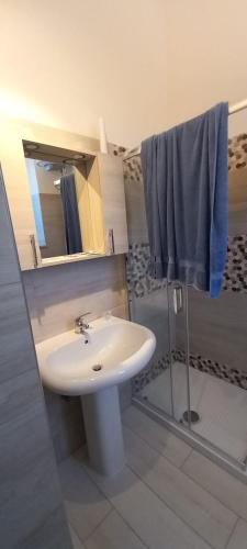 a bathroom with a white sink and a shower at Moon in Pignataro Maggiore