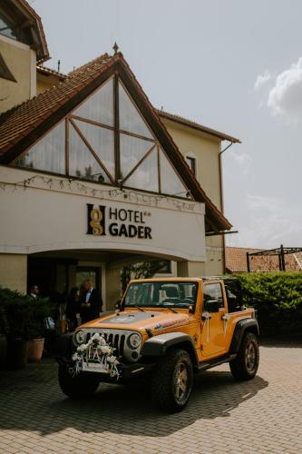 un camion orange garé devant un garage de l'hôtel dans l'établissement Hotel Gader a reštaurácia RaMarti, à Blatnica
