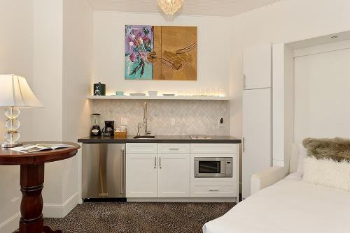 a white kitchen with a sink and a counter at Independence Square 310, Chic, Remodeled Studio w/ Great Location in Aspen, A/C, & Kitchenette in Aspen