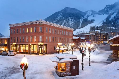 a building with a bunch of lights in the snow at Independence Square 310, Chic, Remodeled Studio w/ Great Location in Aspen, A/C, & Kitchenette in Aspen