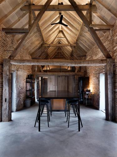 a large room with a table and chairs in it at Hoeve Appartement aan de rand van Maastricht met natuurzwembad in Berg en Terblijt