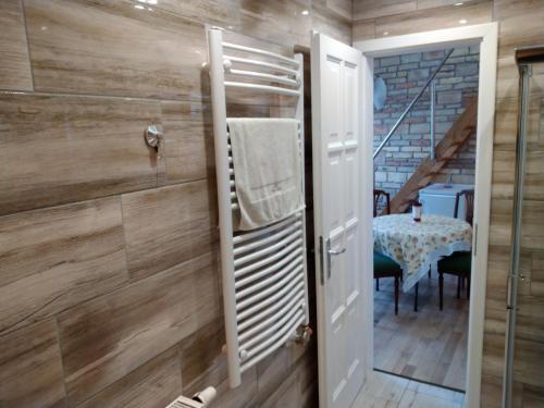 a bathroom with wooden walls and a door with a table at Kisfaludy Károly Apartman in Győr