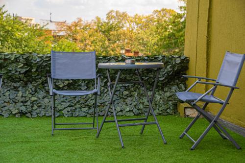 two chairs and a table and two chairs on the grass at Occidental Wise Transit in Bucharest