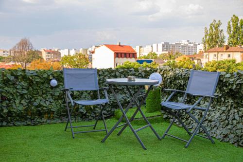three chairs and a table on the grass at Occidental Wise Transit in Bucharest