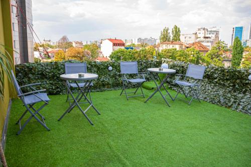 a group of tables and chairs sitting on the grass at Occidental Wise Transit in Bucharest