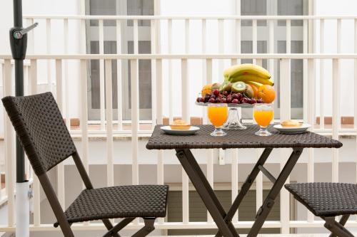 een tafel met een fruitschaal en twee glazen sinaasappelsap bij B&B Vittoria in Gallipoli