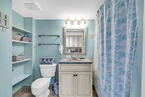 uma casa de banho com um WC, um lavatório e um espelho. em Spacious Oceanfront Condo - Bay Watch 1138 em Myrtle Beach