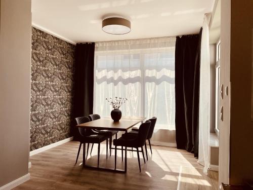 a dining room with a table and chairs and a window at CASA REHSE I Loft-Apartment mit Gartenblick I kostenlos Parken & WLAN I Self-Check-in I 55Zoll-Smart&Kabel-TV I ÖPNV in Erfurt