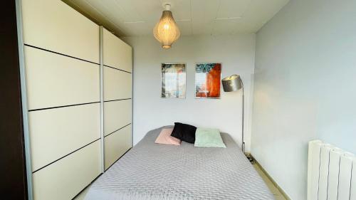 Dormitorio pequeño con cama y lámpara en Côté Sud - Vue mer Stella-Plage, en Cucq