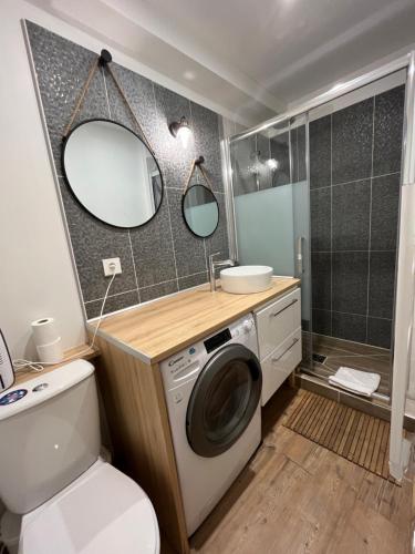 a bathroom with a washing machine and a sink at La Cour Chartraine - Cosy appartement avec cour extérieur à Blois in Blois