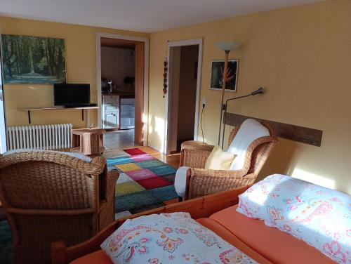 a living room with chairs and a bed and a television at Bio Gesundheitshotel Haus Sonnenstein in Salem