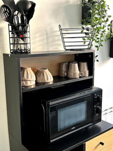 d'un four micro-ondes avec des ustensiles de cuisine. dans l'établissement Le Blue Twin, au Havre