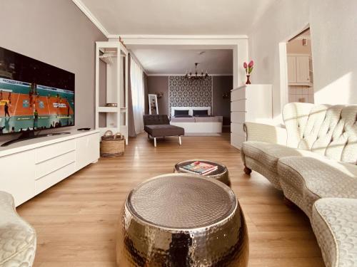 - un salon avec un canapé et une télévision dans l'établissement CASA REHSE I Stilvolles Apartment I 24h-Self-Check-in I kostenlos Parken & WLAN I 55-Zoll-Smart&Kabel-TV I ÖPNV, à Erfurt