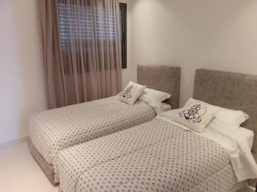 two beds sitting next to each other in a bedroom at Hawaii piscine-pool in Kenitra