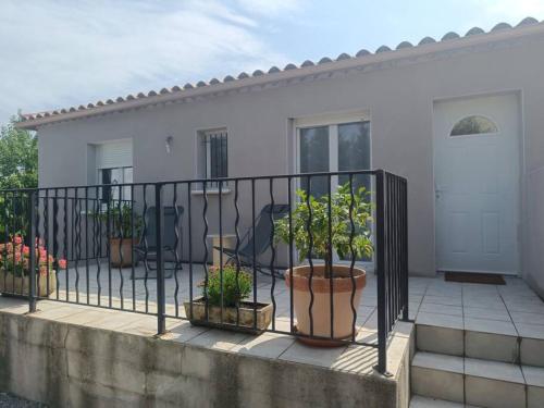 a black fence with potted plants on a patio at Maison au cœur du Pic Saint Loup in Sainte-Croix-de-Quintillargues