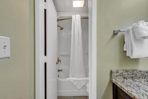 La salle de bains est pourvue d'une douche avec rideau de douche blanc. dans l'établissement Compass Cove Resort 1052, à Myrtle Beach