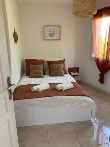 une chambre avec un grand lit avec deux serviettes dessus dans l'établissement Maison au cœur du Pic Saint Loup, à Sainte-Croix-de-Quintillargues