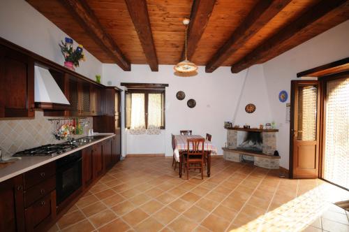 cocina con techos de madera, mesa y sillas en BB Casavacanze Corneto en Bomba