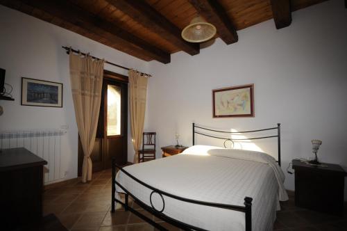 a bedroom with a white bed and a window at BB Casavacanze Corneto in Bomba