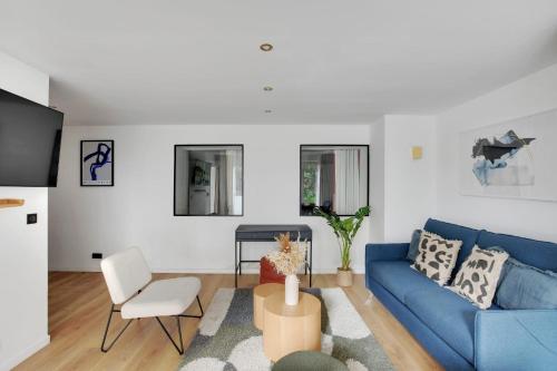 - un salon avec un canapé bleu et une chaise dans l'établissement Chic 3-Bedroom Parisian Apartment in Vibrant Vincennes, à Paris
