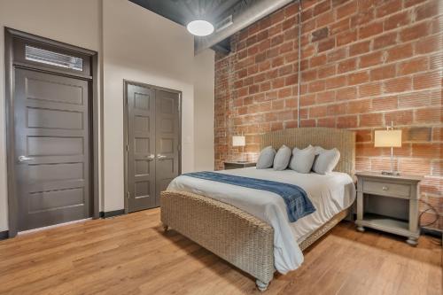 a bedroom with a bed and a brick wall at 2 Bedroom Loft @ Grand Strand Brewery 205 in Myrtle Beach