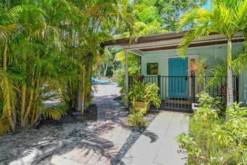 a house with a blue door and palm trees at Siesta Key Palms Resort in Sarasota